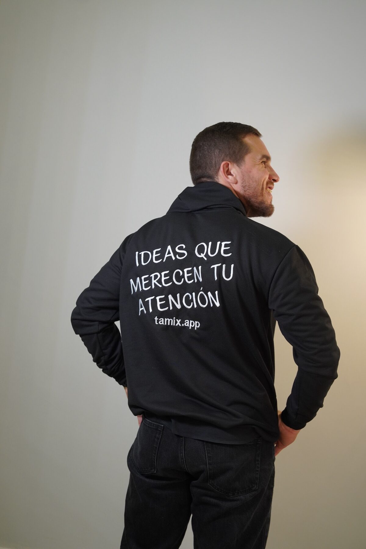 Espalda del buzo de Tamix con el lema «Ideas que merecen tu atención» y la dirección tamix.app